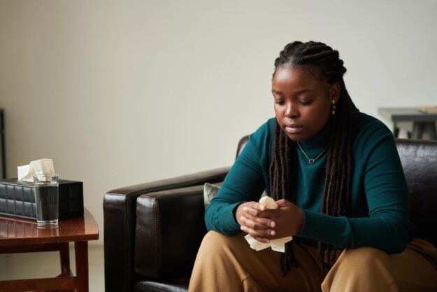 a woman waits to meet with a therapist for mental health treatment