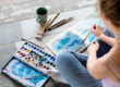 a woman does watercolors in her art therapy program