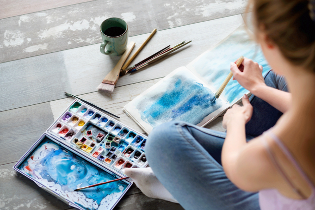 a woman does watercolors in her art therapy program